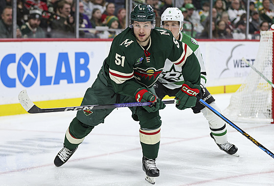 Adam Ra�ka v zeleném dresu Minnesota Wild, stíhá ho Nils Lundkvist z Dallas...