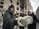 Dobrovolníci odklízejí trosky po dalím vzduném úderu na Kyjev. (3. ledna 2024)