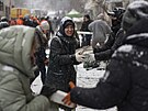 Dobrovolníci odklízejí trosky po dalím vzduném úderu na Kyjev. (3. ledna 2024)