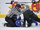 ároví rozhodí od sebe odtrhávají hráe v semifinálovém utkání hokejového...