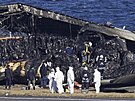 Ohoelé trosky letadla spolenosti Japan Airlines zabírají jednu ze ty...