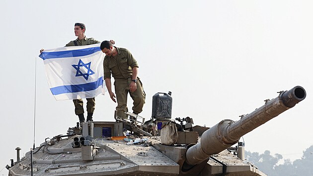 Izraelsk vojk dr izraelskou vlajku na tanku. (1. ledna 2024)