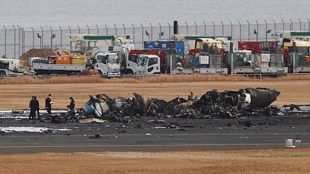 Po nehod na letiti Haneda v Tokiu zstaly na ranveji ohoel trosky stroje. Z letadla spolenosti Japan Airlines se vichni cestujc dostali v podku ven. (3. ledna 2024)