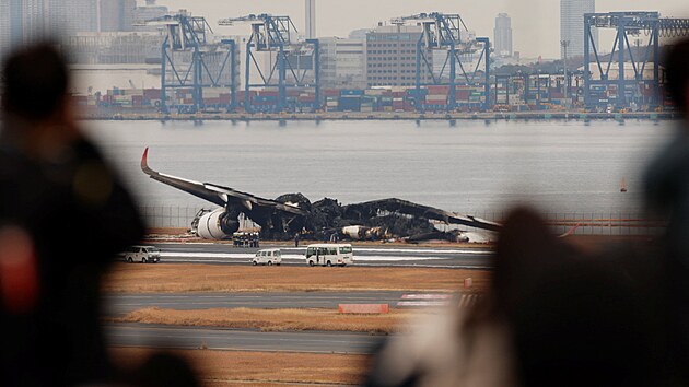 Po nehod na letiti Haneda v Tokiu zstaly na ranveji ohoel trosky stroje. Z letadla spolenosti Japan Airlines se vichni cestujc dostali v podku ven. (3. ledna 2024)
