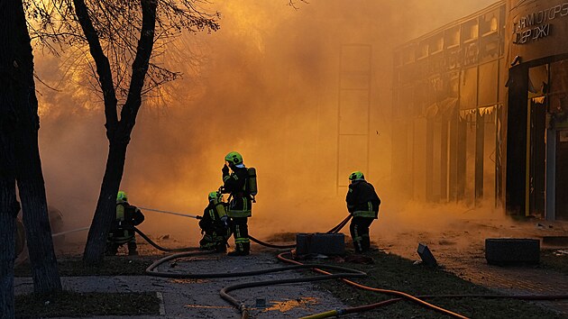 Ukrajint hasii zasahuj v Kyjev, kde po ruskm toku zaala hoet budova. (2. ledna 2024)