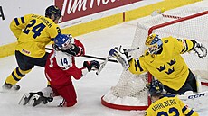 �eský úto�ník Adam �idlický inkasuje úder hokejkou do obli�eje od �védského...