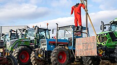 Traktor s pipevnnou ibenicí na znamení protestu je zaparkován mezi mnoha...