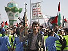 Mu drí zbra bhem protiamerické demonstrace v jemenském Saná. (5. ledna 2024)