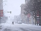Chodci pecházejí ulici v zasnených podmínkách v Des Moines ve stát Iowa....