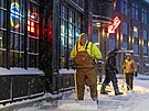 Dlníci odklízejí sníh z chodník v Ankeny ve stát Iowa. (12. ledna 2024)