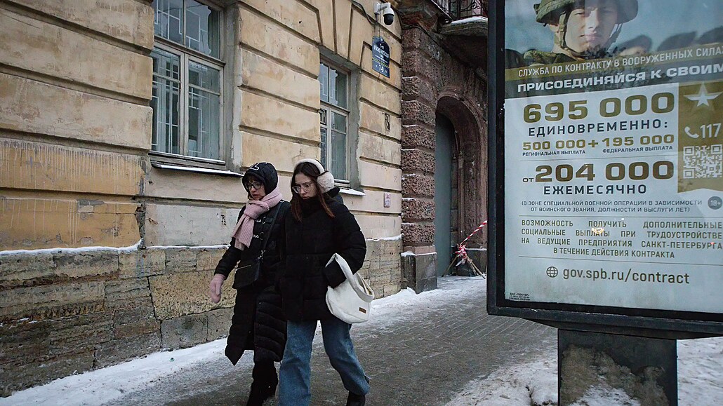 Dv Rusky procházejí kolem armádního náborového billboardu v Petrohradu. (14....