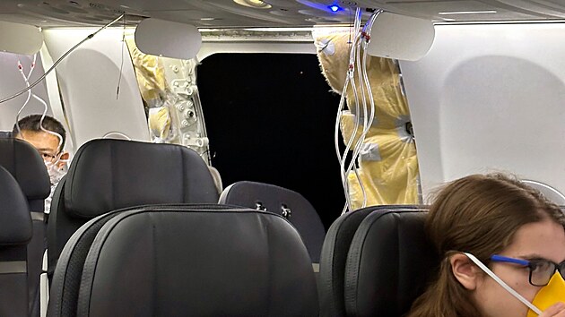 Na snmku jsou cestujc u dry v trupu letadla Boeing 737 Max 9 spolenosti Alaska Airlines, let 1282, kter se muselo vrtit na mezinrodn letit v Portlandu. (5. ledna 2024)