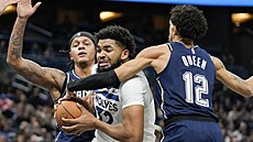 Karl-Anthony Towns (uprost�ed) z Minnesoty brán�ný Paolem Bancherem (vlevo) a...