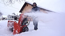 Mu odklízí sníh ze své píjezdové cesty pomocí snhové frézy v Sioux City ve...