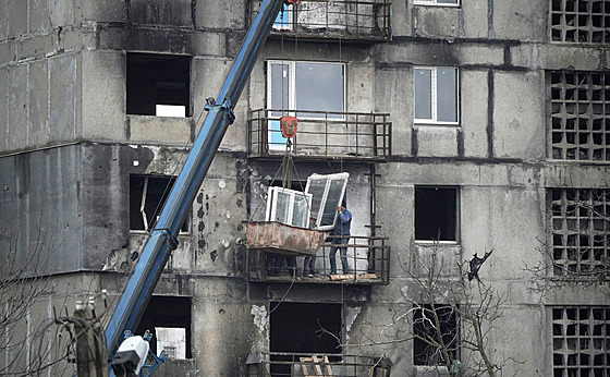 Dlníci v Mariupolu vkládají nová okna. (30. listopadu 2023)