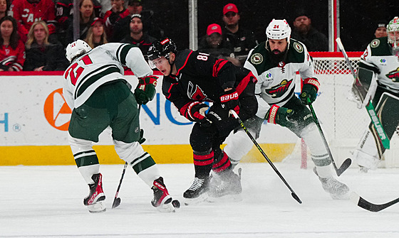 Martin Neas (druhý zleva) z Caroliny brání Zacha Bogosiana (vlevo) z Minnesoty.