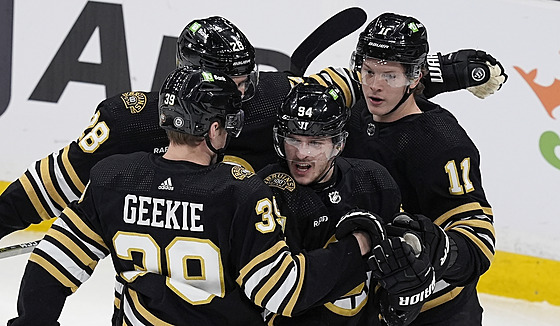 Jakub Lauko (druhý zprava) z Bostonu se raduje se spoluhrái z gólu v zápase s...