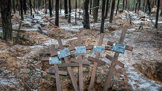 Pohled na prázdné hroby na hromadném pohřebišti vedle hřbitova v Iziumu na Ukrajině. Po jeho  osvobození ukrajinskou armádou bylo v masovém hrobě nalezeno přes 440 těl. )28. ledna 2024)