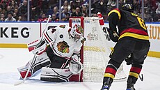 Branká Petr Mrázek z Chicaga likviduje anci Brocka Boesera z Vancouveru.