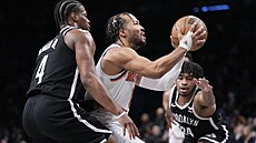 Jalen Brunson (uprost�ed) z New Yorku se chystá zakon�it na ko� Brooklynu....