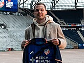 Pavel Bucha pózuje s dresem FC Cincinnati na klubovém stadionu.