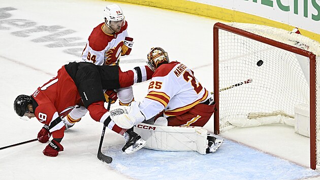 Ond�ej Pal�t z New Jersey pr�v� vst�elil g�l do branky Calgary, kterou h�j� Jacob Markstr�m. Vlevo je obr�nce Brayden Pachal.