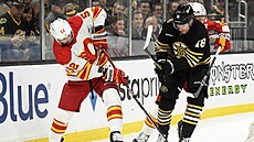 MacKenzie Weegar (vlevo) z Calgary a Pavel Zacha z Bostonu bojují o puk.