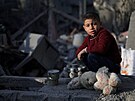 Palestinský chlapec sbírá v troskách budovy jídlo po izraelském útoku na dm v...