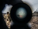 Ukrajinský voják se bhem výcviku dívá dalekohledem na stelnici na blíe...
