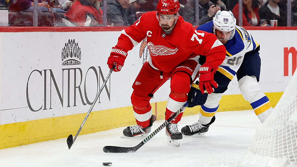 Úto�ník Dylan Larkin z Detroitu si kryje puk p�ed Bradnonem Saadem ze St. Louis.