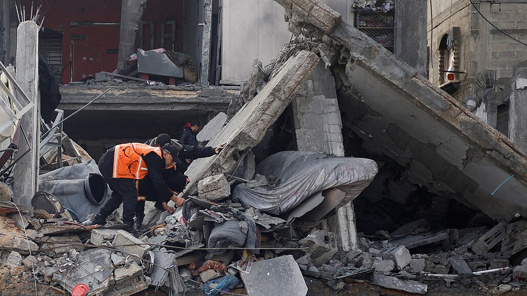 Palestinci prohlíejí trosky po izraelském útoku. (27. února 2024)