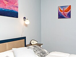 Nad postelí jsou z obou stran umístné praktické lampiky. Místnost oivily...