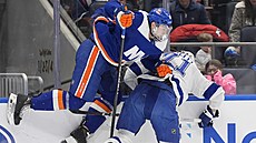 Alexander Romanov z New York Islanders (vlevo) v souboji u mantinelu s Anthony...