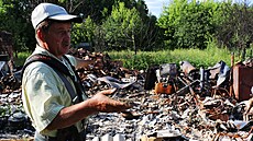 Mu� ukazuje zam�stnanc�m organizace �lov�k v tísni zbytky jeho domu, který...
