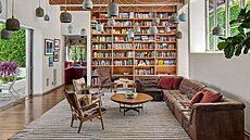 Prostorný obývací pokoj má police na knihy od podlahy a ke stropu.