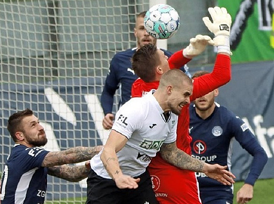 Karvinský obránce Douglas Bergqvist naskakuje do souboje s branká�em Slovácka...