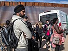 Migranti z Indie a Haiti ekají na pevoz do detenního centra v Arizon....