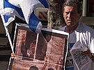 Izraelský pravicový demonstrant v Tel Avivu drí plakát s fotomontáí, na ní...