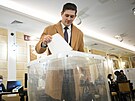 Mu vhazuje hlasovací lístek bhem prezidentských voleb v Moskv. (15. bezna...