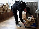 Zákazník si váí balíky v bruselském obchod Pile ou Face (15. bezna 2024)