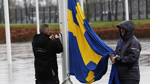 Pipevovn vdsk vlajky pi pprav na slavnostn vztyen vlajky u pleitosti vstupu vdska do NATO v sdle NATO v Bruselu (11. bezna 2024)