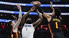 James Harden z LA Clippers mezi dvojicí Vít Krej�í (vlevo) a  Jalen Johnson z...