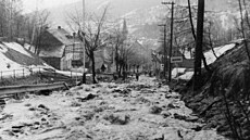 Proudy vody valící se dol� do Jáchymova z protr�ené hráze M�stského rybníka.