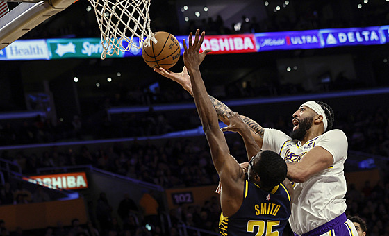 Anthony Davis (vpravo) z Los Angeles Lakers zakonuje pes bránícího Jalena...