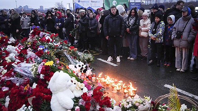 Lid se shromauj, aby poloili kvtiny a zaplili svky u Crocus City Hall na zpadnm okraji Moskvy. (23. bezna 2024)