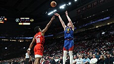 Christian Braun z Denver Nuggets stílí pes blokujícího Scoota Hendersona z...