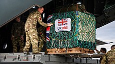 Písluník 47. letky RAF nakládá humanitární pomoc do letounu RAF A400M, který...