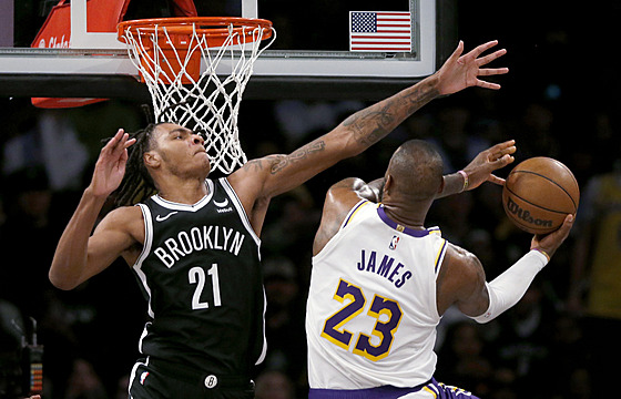 LeBron James (23) z LA Lakers zakonuje na ko Brooklynu, brání ho Noah Clowney...