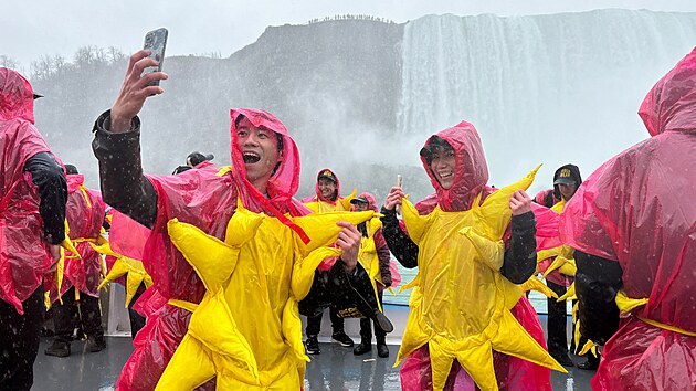 Nkte z 309 lid, kte se shromdili, aby pekonali Guinnessv rekord v potu lid obleench jako slunce, pzuj na vyhldkov lodi ped plnm zatmnm Slunce u Niagarskch vodopd v kanadskm Ontariu. (8. dubna 2024)