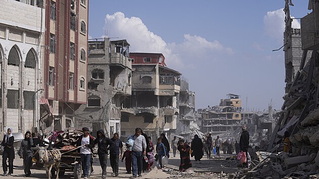 Palestinci prochzej znienmi budovami po izraelsk leteck a pozemn ofenziv v Chn Jnisu na jihu Psma Gazy. (8. dubna 2024)